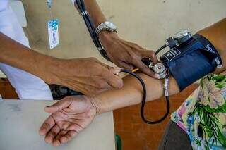 Profissional de saúde aferindo pressão de paciente. (Foto: Divulgação | Secretaria de Saúde de Corumbá) 