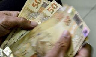 Cédulas de R$ 50 são contadas após saque (Foto: Agência Brasil)