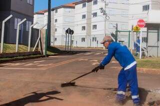 Funcionário faz limpeza em frente a residencial a serviço da Prefeitura de Campo Grande. (Foto: Marcos Maluf)