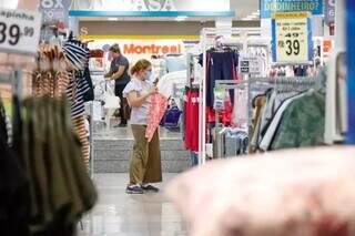 Mulher observa peças de roupas em loja do comércio da Capital (Foto: Henrique Kawaminami/Arquivo)