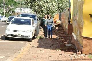 Hmais de dois meses, amigas disputam espaço com restos de obra na Rua Bahia ao seguir para o trabalho. (Foto: Kísie Ainoã)
