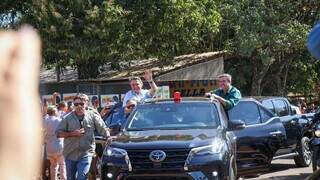 Jair Bolsonaro, amparado por segurança e Eduardo Riedel, desfilando em carro aberto. (Foto: Henrique Kawaminami)