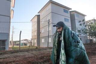 Enrolado em cobertor, Daniel caminha atrás de residencial inaugurado hoje na Capital pelo presidente da República. (Foto: Marcos Maluf)
