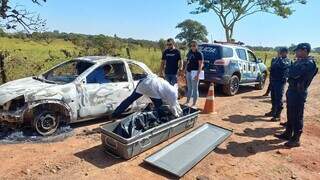 Perícia e policiais no local onde o carro foi encontrado com restos mortais. (Foto: Viviane Oliveira)