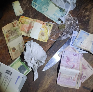 Dinheiro e porção de maconha apreendida durante a operação. (Foto: Polícia Civil)