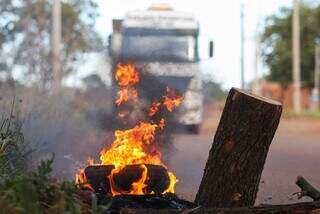 Pneus, fogo e troncos de galhos impedem a passagem de carretas em rua do Indubrasil. (Foto: Henrique Kawaminami)