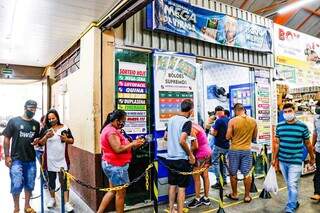 Fila de apostadores em lotérica da Capital. (Foto: Henrique Kawaminami)