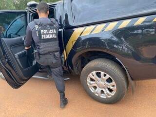 Agente da PF entra em viatura em local das buscas em Batayporã (Foto: Divulgação)