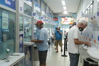 Clientes sendo atendidos em lotérica, ponto de encontro para as apostas na Mega-Sena. (Foto: Kísie Ainoã)