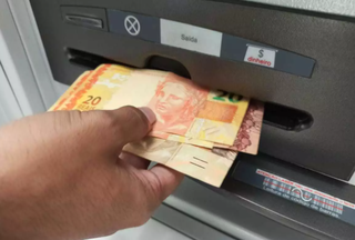 Dinheiro sendo sacado em caixa automático. (Foto: Arquivo/Campo Grande News)