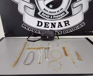 Bolsa e joias que foram recuperadas pela equipe da Denar nesta quarta-feira (20), em Campo Grande (Foto: Denar)
