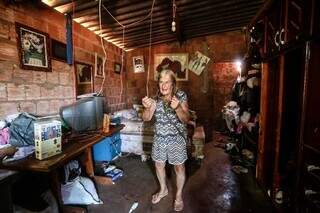 Dona Miria mostra a casa dela, de um cômodo, onde moram 11 pessoas. (Foto: Marcos Maluf)