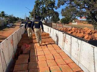 Policiais rodoviáros tiveram de tirar tijolos que estavam no caminhão. (Foto: Reprodução/PRF)