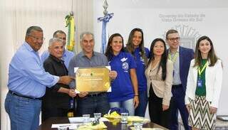 Atletas, representantes da confederação e patrocinadores do evento reunidos com o governador Reinaldo Azambuja. (Foto: Divulgação)