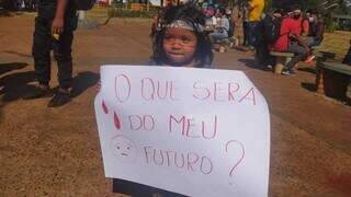 Criança indígena mostra cartaz durante ato hoje em Dourados (Foto: Giovanni Coletti/Divulgação) 