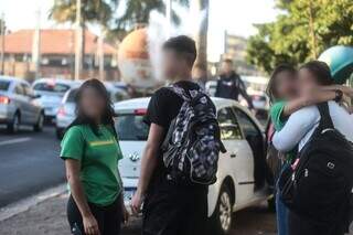 Rapaz fuma e alunos se abraçam em frente a colégio. (Foto: Marcos Maluf)