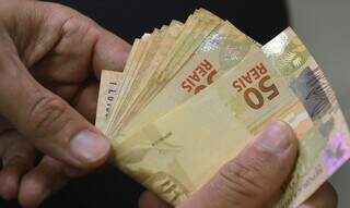 Notas de R$ 50 são contadas após saque (Foto: Agência Brasil)
