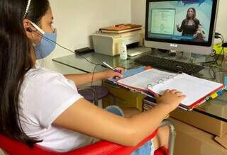 Aluna assistindo aulas remotamente durante a pandemia (Foto: PMCG/Divulgação)