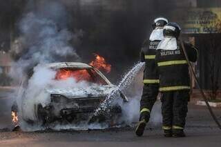Bombeiros combate as chamas no Ford Ka, esta manhã, no Jardim Noroeste. (Foto: Marcos Maluf)