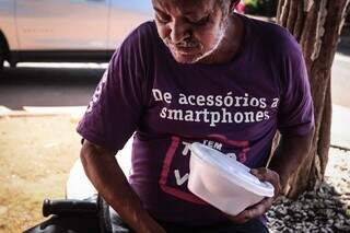 Aposentado Eduardo dos Santos quando retirava sua marmita. (Foto: Marcos Maluf)