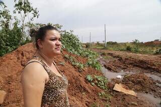 Moradora da Rua Indianápolis, dona de casa Suelen Lopes Corrêa, de 33 anos, mostra a situação da via alagada (Foto: Kísie Ainoã)