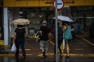 Moradores caminham pelo Centro da Capital, durante manhã chuvosa. (Foto: Henrique Kawaminami)