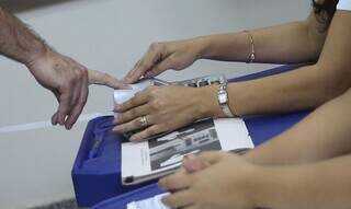 Os mesários trabalham nas mesas receptoras de votos ou de justificativa, dando andamento à fila de votação. (Foto: Agência Brasil)