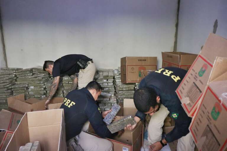 Policiais fazendo a contagem dos tabletes de maconha para pesagem. (Foto: Paulo Francis)