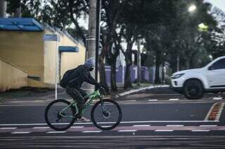 Com luvas e touca, ciclista se protege do frio na Avenida Afonso Pena (Foto: Henrique Kawaminami)