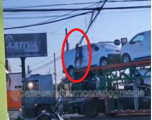 Homem se arrisca erguendo fiação para caminhão-cegonha atravessar a Ceará