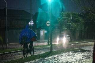 Ciclista precisou usar capa para se proteger da chuva (Foto: Henrique Kawaminami)
