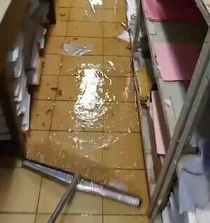 Funcionária tenta retirar água de sala dentro do Hospital Universitário. (Foto: Reprodução / Vídeo)