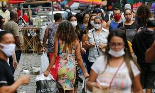 População caminha com máscaras no rosto. (Foto: Agência Brasil)
