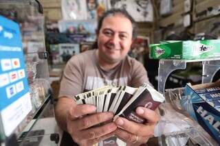 Com figurinhas em mãos, vendedor comemora alta procura dos intens na Capital (Foto: Marcos Maluf)