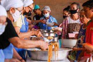 Voluntários distribuem alimentos todos os sábado em paróquia de Campo Grande. (Foto: Henrique Kawaminami)