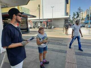 Atendente de pizzaria Rogério Moraes, entregando panfletos de candidato a deputado estadual, no Centro da Capital. (Foto: Caroline Maldonado)