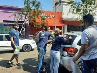 Equipe de campanha adesivando carro na Rua 14 de Julho. (Foto: Caroline Maldonado)