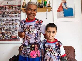 Basílio com camiseta comemorativa ao lado do neto. (Foto: Aletheya Alves)