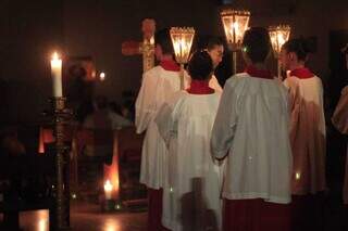 Coroinhas entrando na igreja, que fez a missa à luz de velas, na noite de domingo (Foto: Alex Machado)
