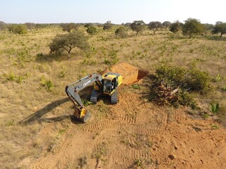 Máquina escavadeira que cavava buracos para enterrar árvores foi apreendida. (Foto: PMA)