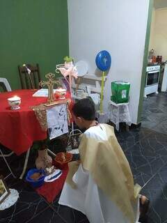 Menino que sonha em ser padre segue todos os rituais da missa durante celebração em casa. (Foto: Divulgação)