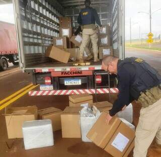 Policiais descarregam caixas de caminhão que levava maconha e munições para SP (Foto: Divulgação)