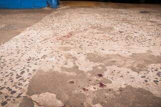 Manchas de sangue na calçada de oficina, na manhã desta terça-feira (Foto: Henrique Kawaminami)