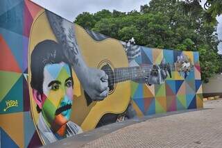 Pintura em paredão na praça do pé de cedro (ao fundo) em Coxim, onde haverá inauguração de estátua em homeanagem a Zacarias Mourão. (Foto: Prefeitura de Coxim)