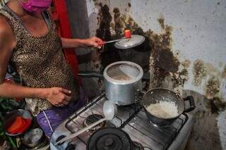 Moradora da Cidade de Deus mostrando as panelas de comida quase vazias (Foto: Marcos Maluf)