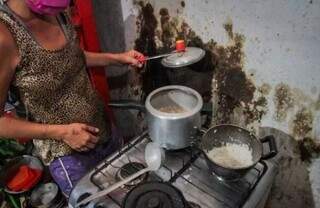 Moradora da Cidade de Deus mostrando o que tem para comer em casa (Foto: Marcos Maluf)