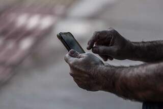 Com celular em mãos, homem tenta conectar sinal do 5G (Foto: Marcos Maluf)