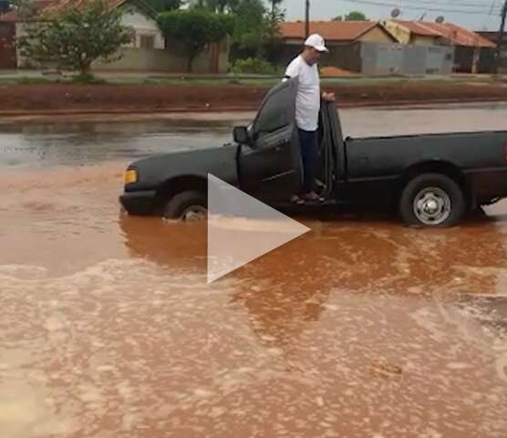 Motorista cai com caminhonete em buraco inundado pela chuva no Nova Campo Grande