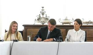 Bolsonaro e primeira-dama durante assinatura da lei. (Foto: Agência Brasil)