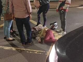Pedestre ficou estirada no chão após ter sido atingida por motocicleta. (Foto: Geniffer Rafaela)